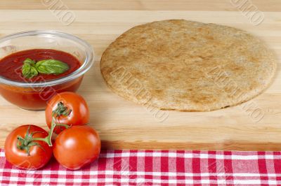 pizza dough fresh tomatoes and tomato sauce with basil leaf