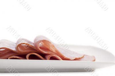 slices ham on a white plate