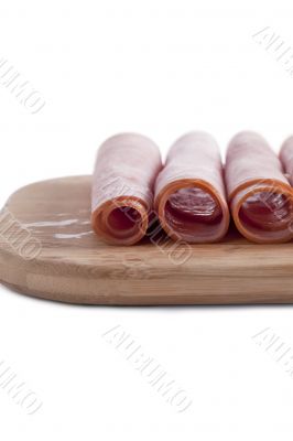 rolls of ham in wooden plate
