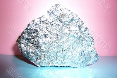 Gray shiny stone on a pink-blue background.