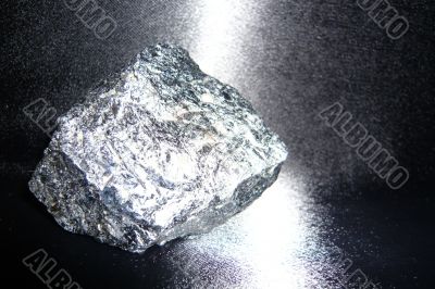Silvery shiny stone on a black background.