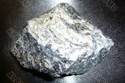 Silvery shiny stone on a black background
