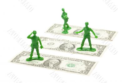 military toy soldier standing over the dollar bill