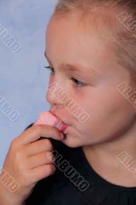 Beautiful small girl eating sweetmeat