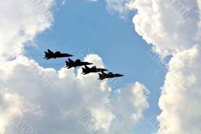 Four fighters on the background of white clouds