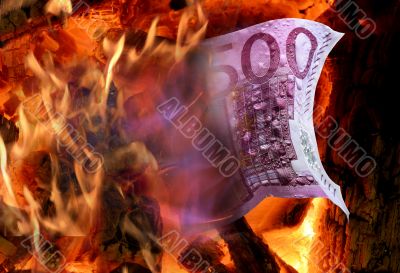 The wood fire burns a five hundred euro banknote
