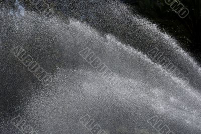 Splashing of the fountain playing with the rays of the sun