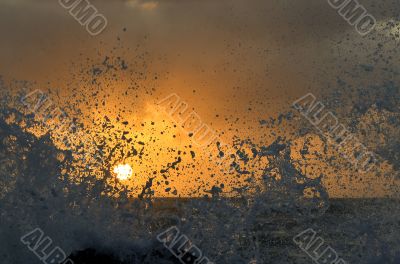 Splashes of high waves obscure the sun