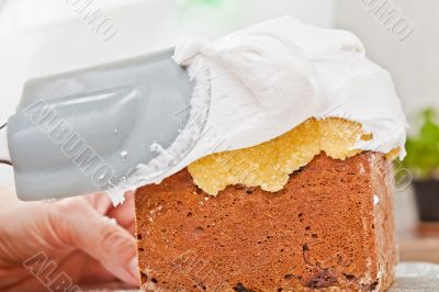 Spreading cream on cake icing