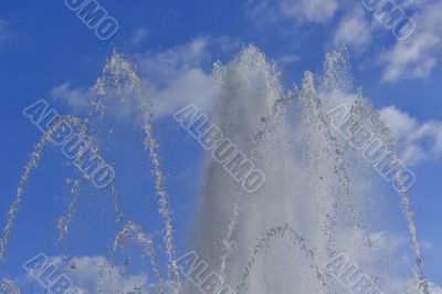 Water jets of a fountain on the blue sky