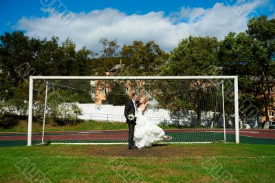 Bride and groom on the football field