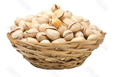 Pistachio nuts in a wicker plate, isolated