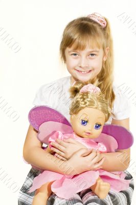 Beautiful little girl playing with a doll
