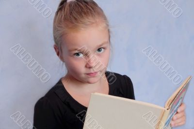 Girl with blond hair reading a book