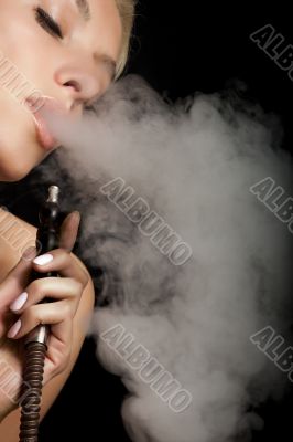 Woman smokes a hookah