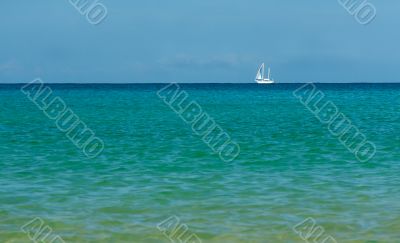 white sailboat on the azure sea