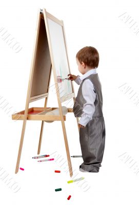A child paints on an easel in the studio