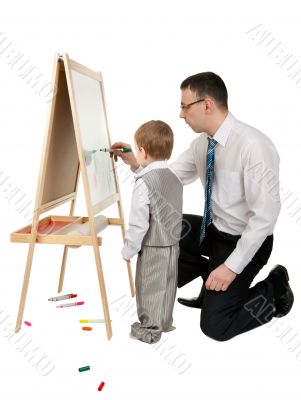 Businessman teaches his son to paint on an easel