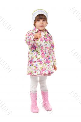 little girl in boots and a jacket shows finger
