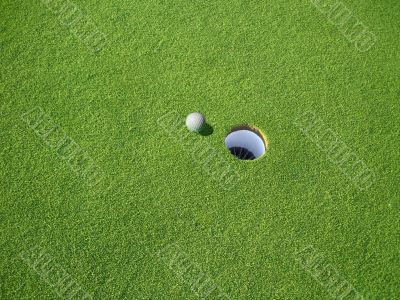 Golf Ball on Green Near Hole