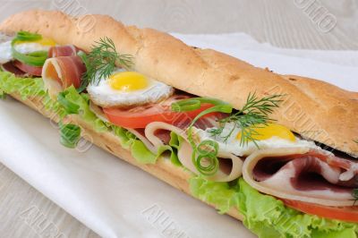 Big sandwich with ham, tomato and quail egg