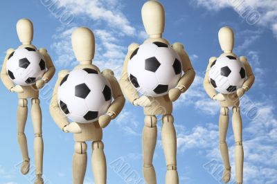 Four wooden figures with soccer balls in the sky