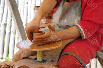 hands of a potter, creating an earthen jar on the circle 
