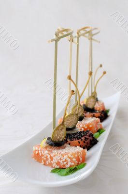 Pieces of salmon in sesame with capers
