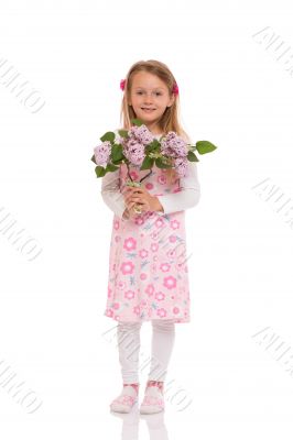 Smiling little girl with lilac flowers