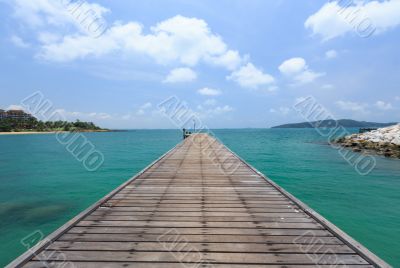 Wooden footbridge over the water near the beach 