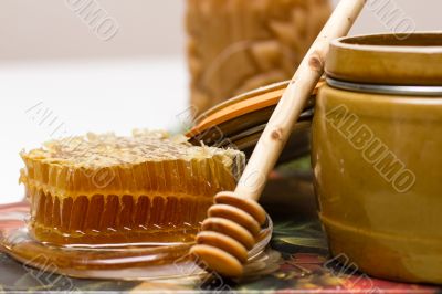 Honey in pot, honeycomb and stick