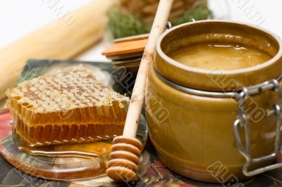 Honey in pot, honeycomb and stick