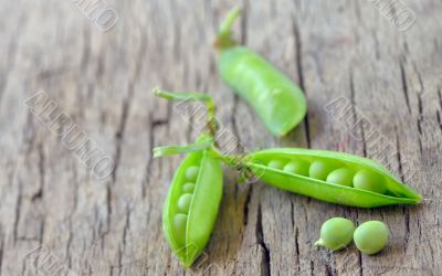 Fresh green peas on an old wooden background