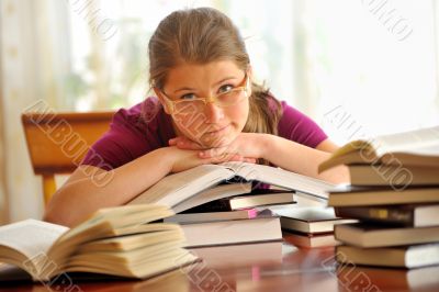 Teen girl learning at the desk, looking up