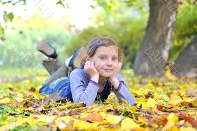 little girl lays on the leaves