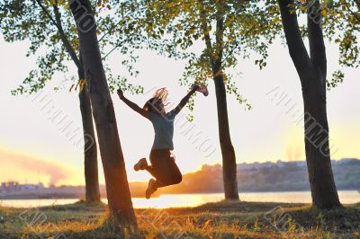 girl jumping over sunset
