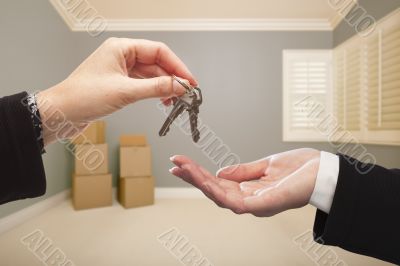 Realtor Handing Over the House Keys Inside Empty Grey Room