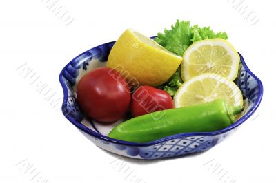 Vase with fruit and vegetables on a white background.