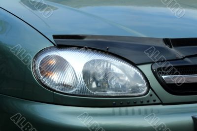 Fragment of a car. The right front headlight