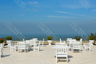 An empty rooftop restaurant with views of the sea