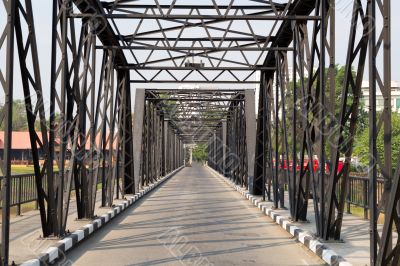 Road through metal bridge tunnel