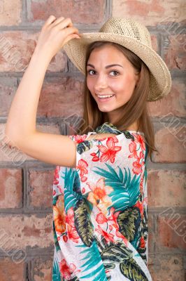 The beautiful girl in a summer hat. Studio portrait