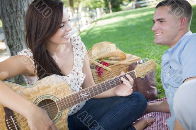 Mixed Race Couple at the Park Playing Guitar and Singing