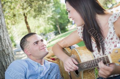 Mixed Race Couple at the Park Playing Guitar and Singing