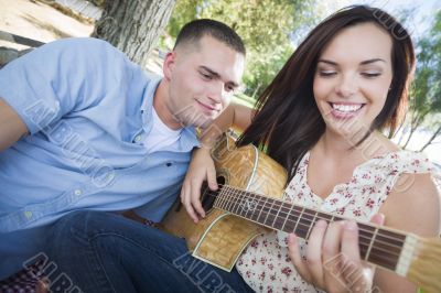 Mixed Race Couple at the Park Playing Guitar and Singing