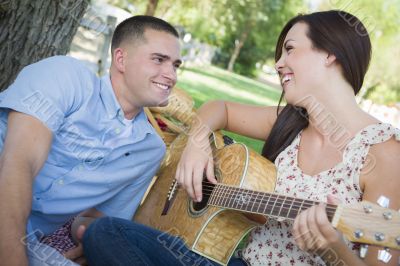 Mixed Race Couple at the Park Playing Guitar and Singing
