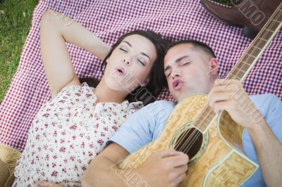 Mixed Race Couple at the Park Playing Guitar and Singing