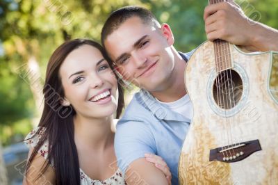 Mixed Race Couple Portrait with Guitar in Park