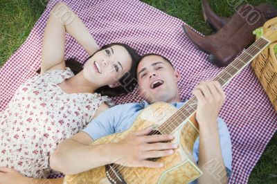 Mixed Race Couple at the Park Playing Guitar and Singing