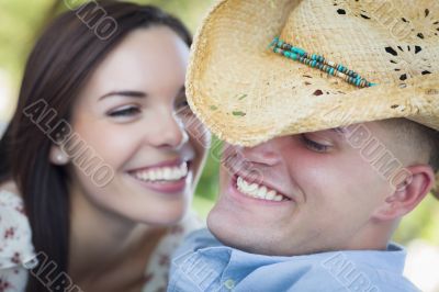 Mixed Race Romantic Couple with Cowboy Hat Flirting in Park